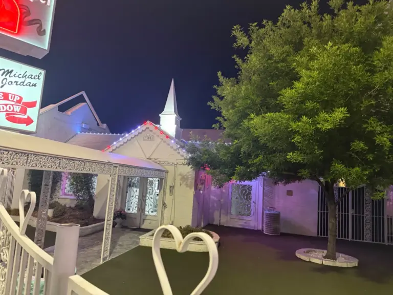 Courtyard view of the Little White Chapel in Las Vegas, NV with permanent lights on the roofline