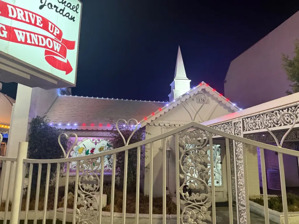 Red and white permanent lights along the roofline and fascia of the Little White Chapel in Las Vegas, NV at night