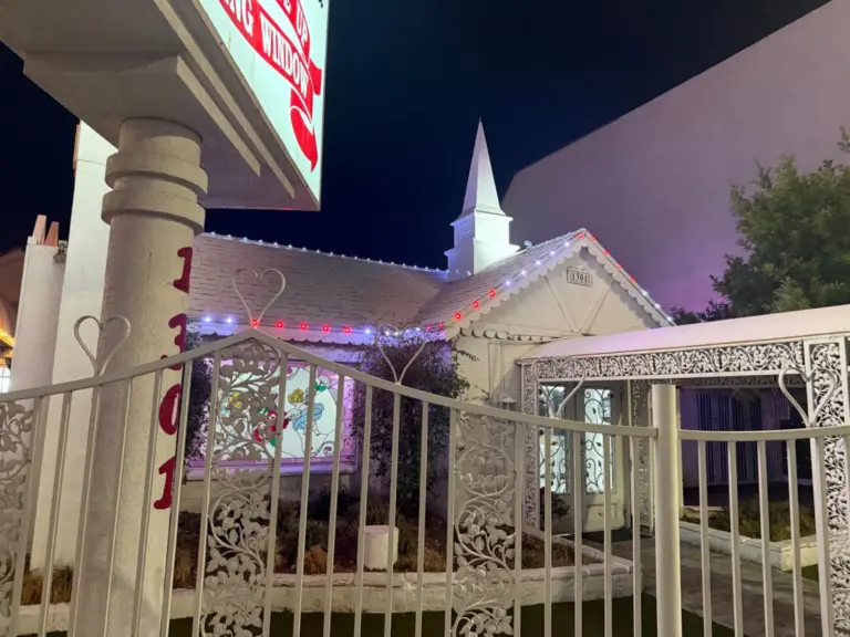 Red and white ridgeline lights on the gable below the white steeple of the Little White Chapel in Las Vegas, NV